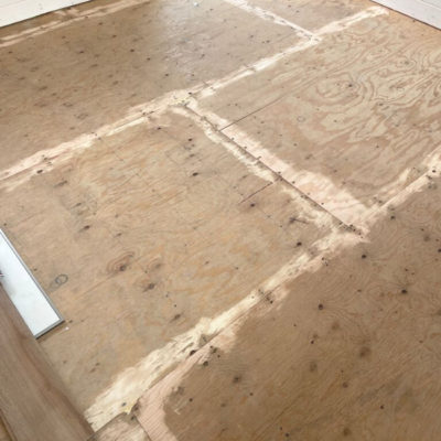 Image depicts old floors from a loose lay vinyl flooring installation project in London, Ontario.